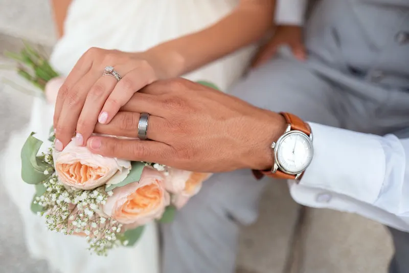 Rings on a bride and a groom with watch