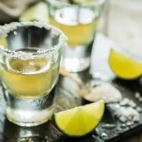 Gold tequila shots on rustic wood background, 1800 Coconut Tequila Recipe, things-that-represent-Mexico, are things cheaper in Mexico, nightlife in Mexico City, 7 Tips When Staying At A Cancun All-Inclusive Resort, Top Hotels in Tequila from $40 and up!￼