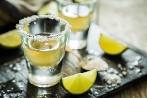 Gold tequila shots on rustic wood background, 1800 Coconut Tequila Recipe, things-that-represent-Mexico, are things cheaper in Mexico, nightlife in Mexico City