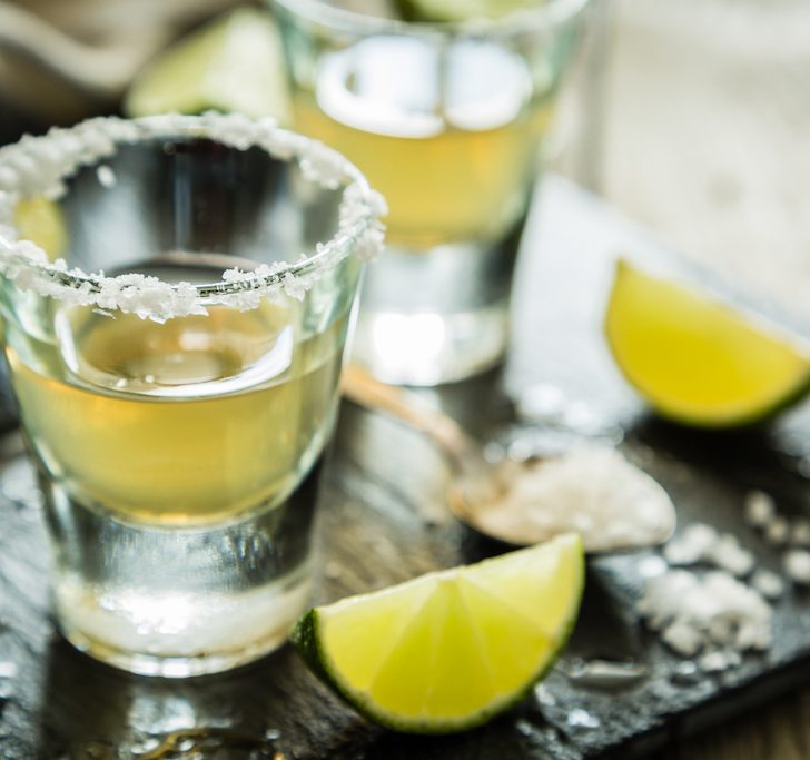Gold tequila shots on rustic wood background, 1800 Coconut Tequila Recipe, things-that-represent-Mexico, are things cheaper in Mexico, nightlife in Mexico City, 7 Tips When Staying At A Cancun All-Inclusive Resort￼
