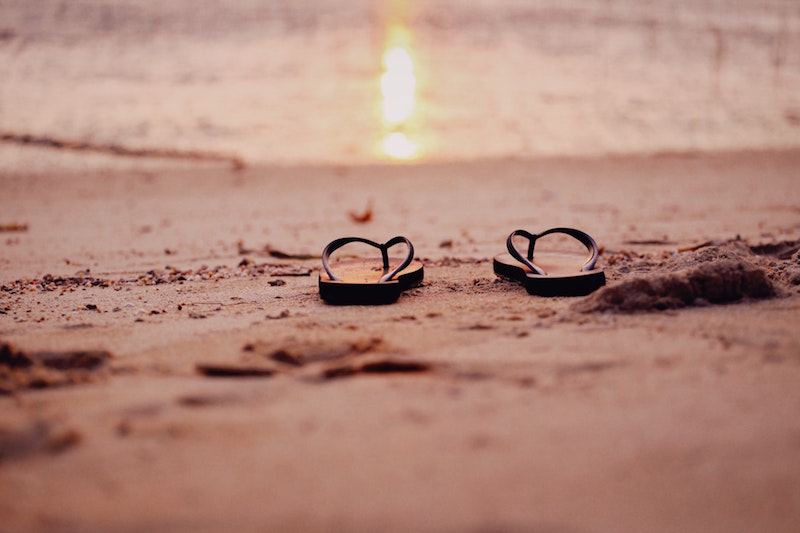 brown flip flops in sand