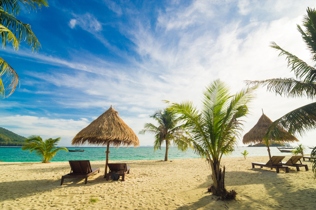 Vacation time background of two beach lounge chairs under grass tent, Tropical bar on a beach on Cozumel island, Mexico, Boat in Water in Cozumel, best food in cozumel, best scuba diving in Cancun