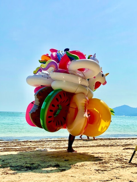 man with balloons on beach, Ko Samui Thailand, Best Islands for Luxury Family Vacations,