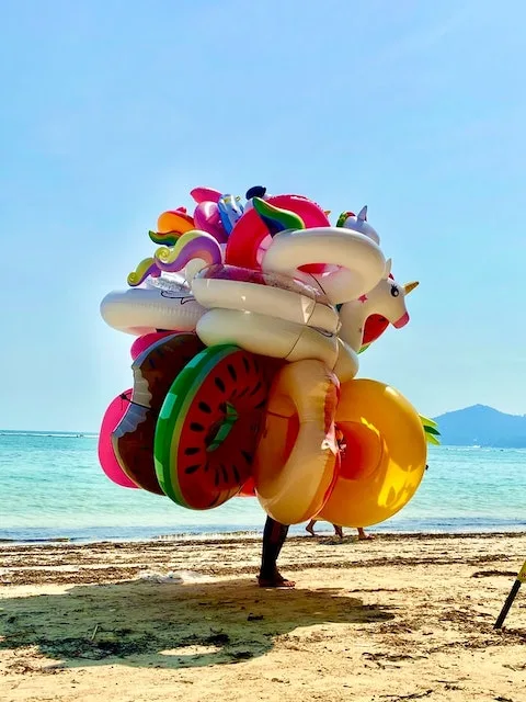 man with balloons on beach, Ko Samui Thailand, Best Islands for Luxury Family Vacations,