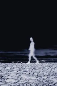 woman walking on a beach, haunted places in Ireland